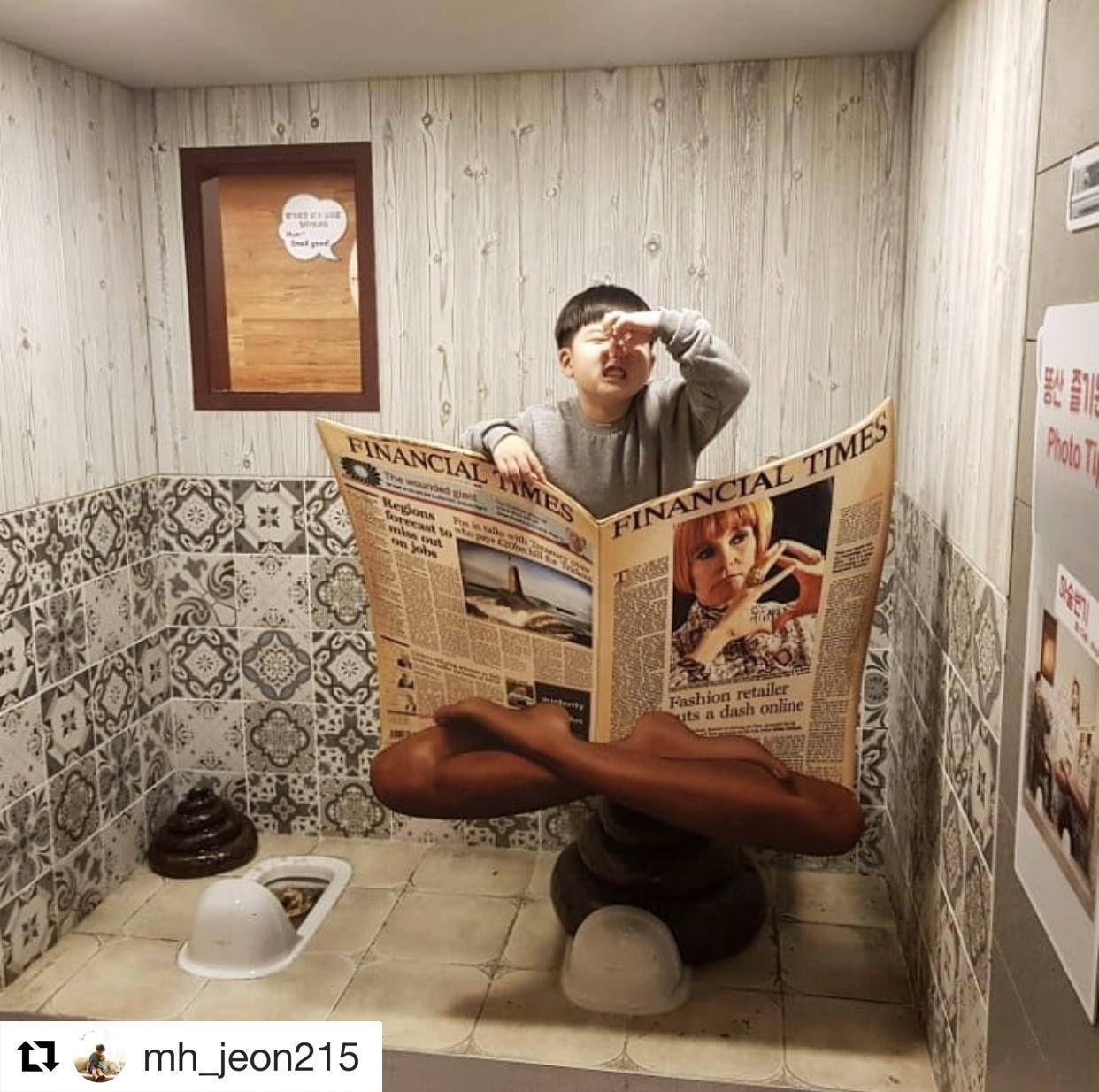 首爾便便主題展覽互動牆，兩個小女生正在與漂浮的大便形狀裝置拍照。